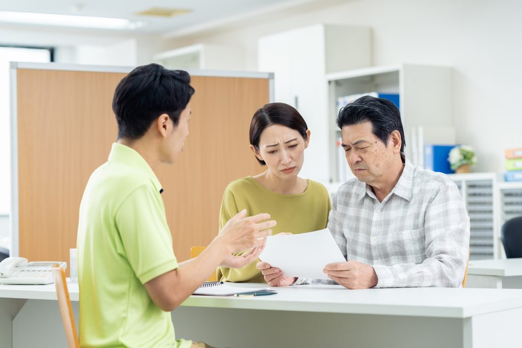 施設の相談員から説明を受ける家族