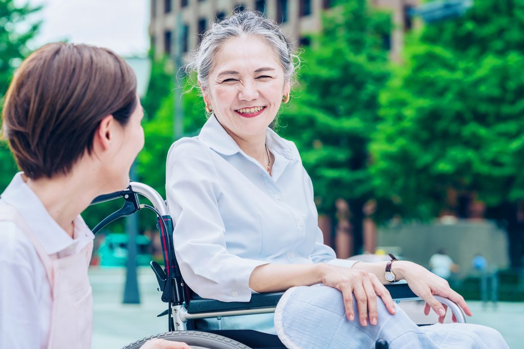 車いすの高齢女性が笑っている写真